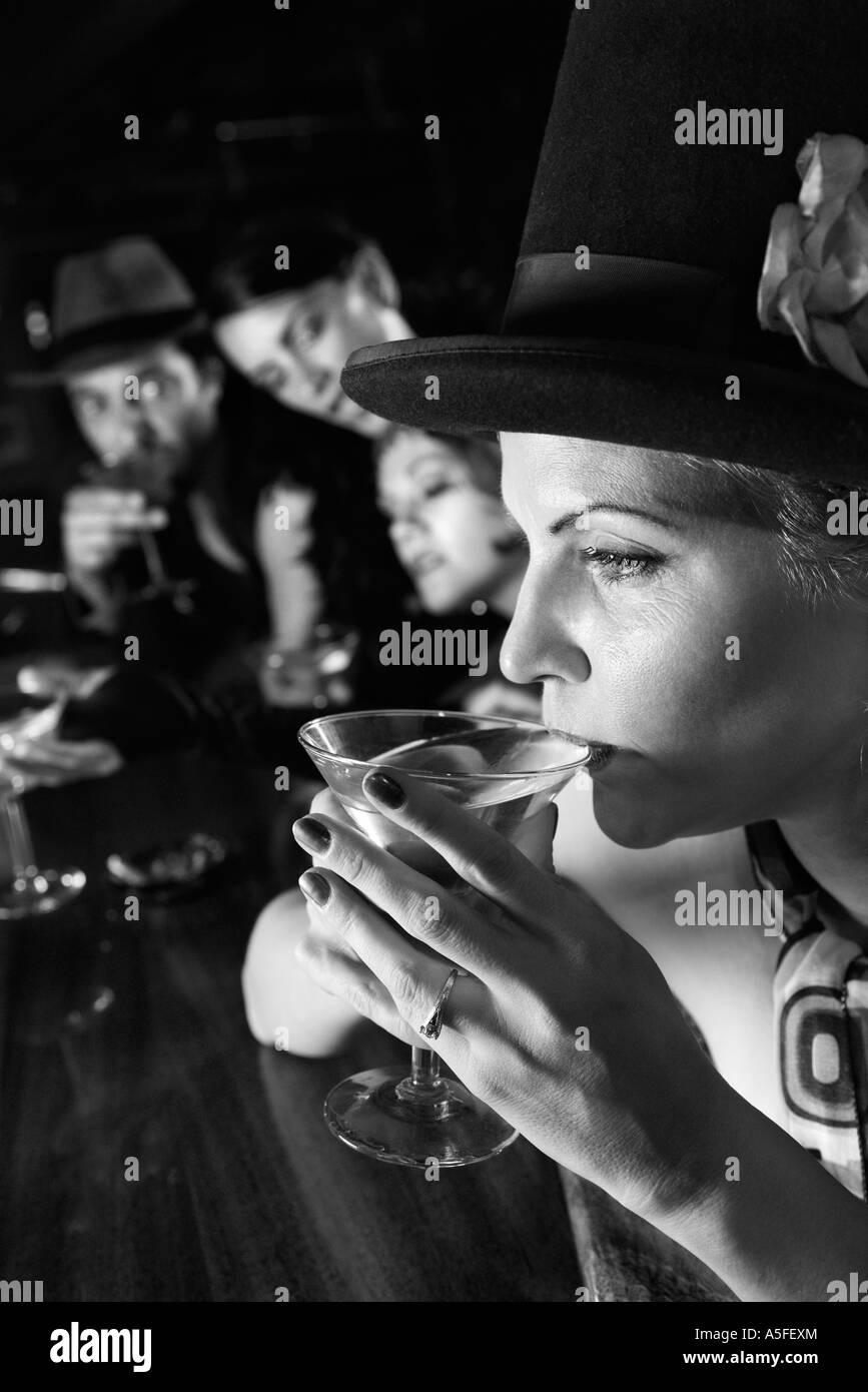 Caucasian prime adult retro female sitting at bar drinking martini Stock Photo