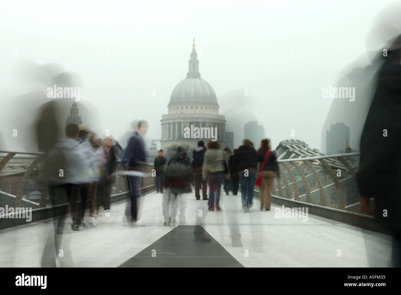 a hazy Saint Pauls cathedral and blurred people on Millennium Bridge Stock Photo