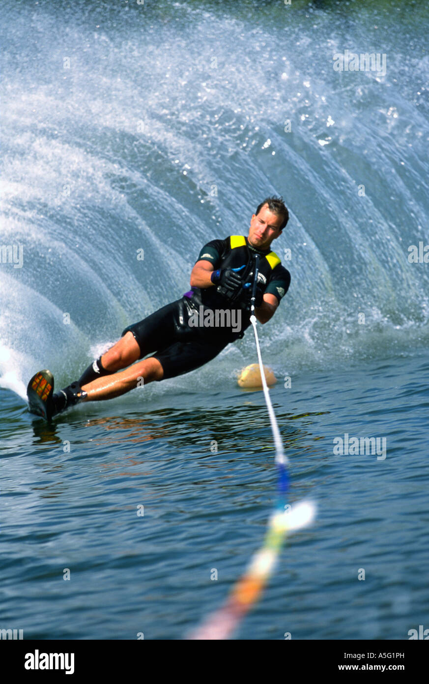 A water skier rounds a buoy on a slalom course set up on a lake Stock