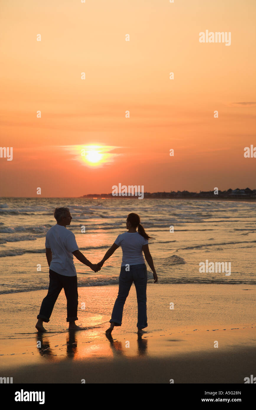Couple walking on beach holding hands hi-res stock photography and ...