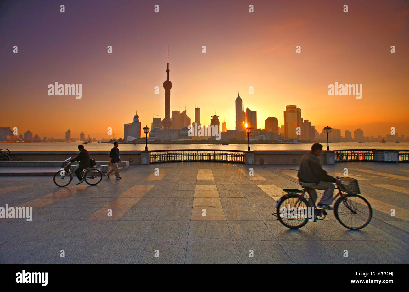 Flying A Kite and bicycling At Sunrise On The Bund Shanghai China Stock Photo