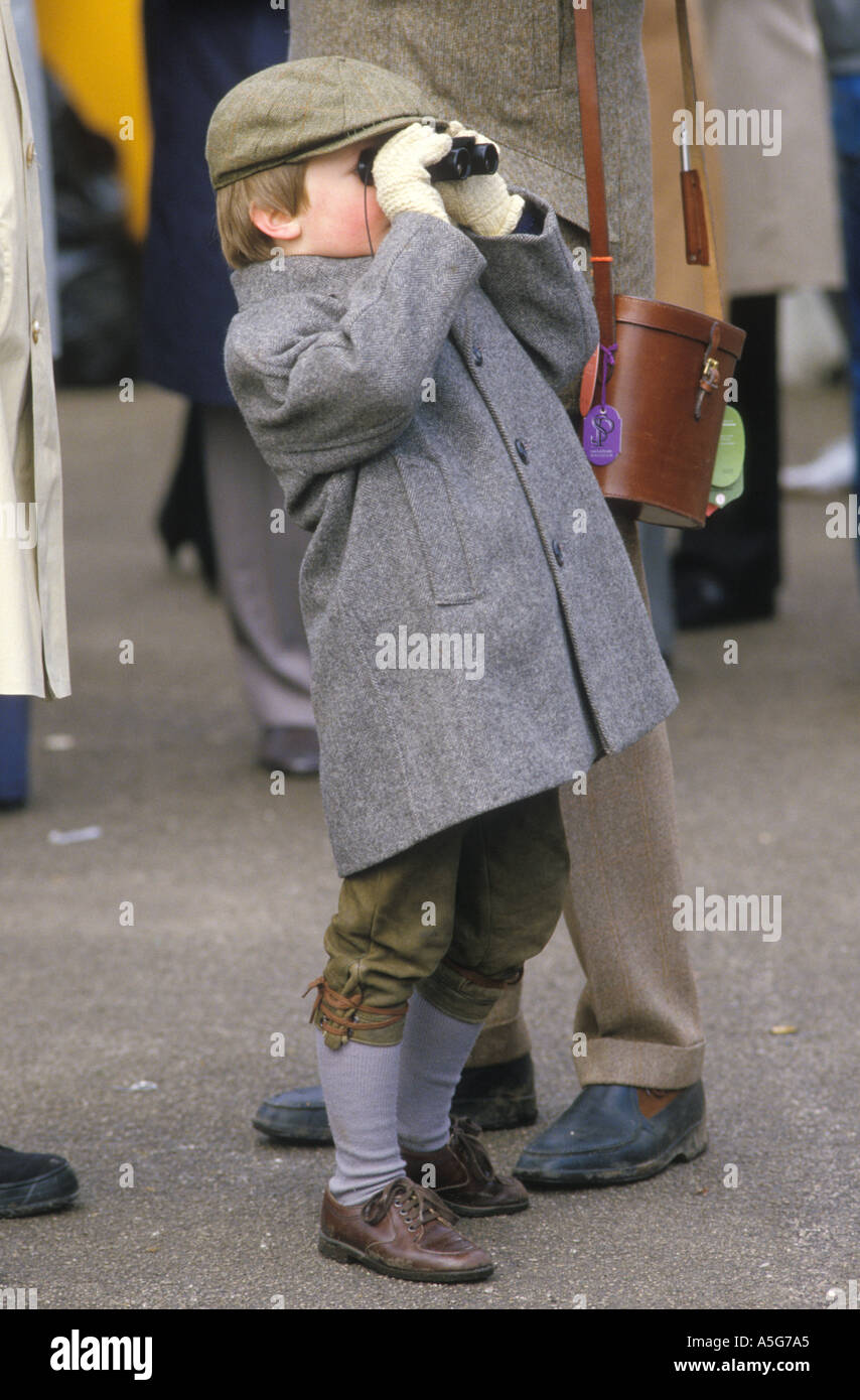 Like father like son a young boy with binoculars at the Grand National Horse Race Aintree Lancashire England UK 1980S HOMER SYKES Stock Photo