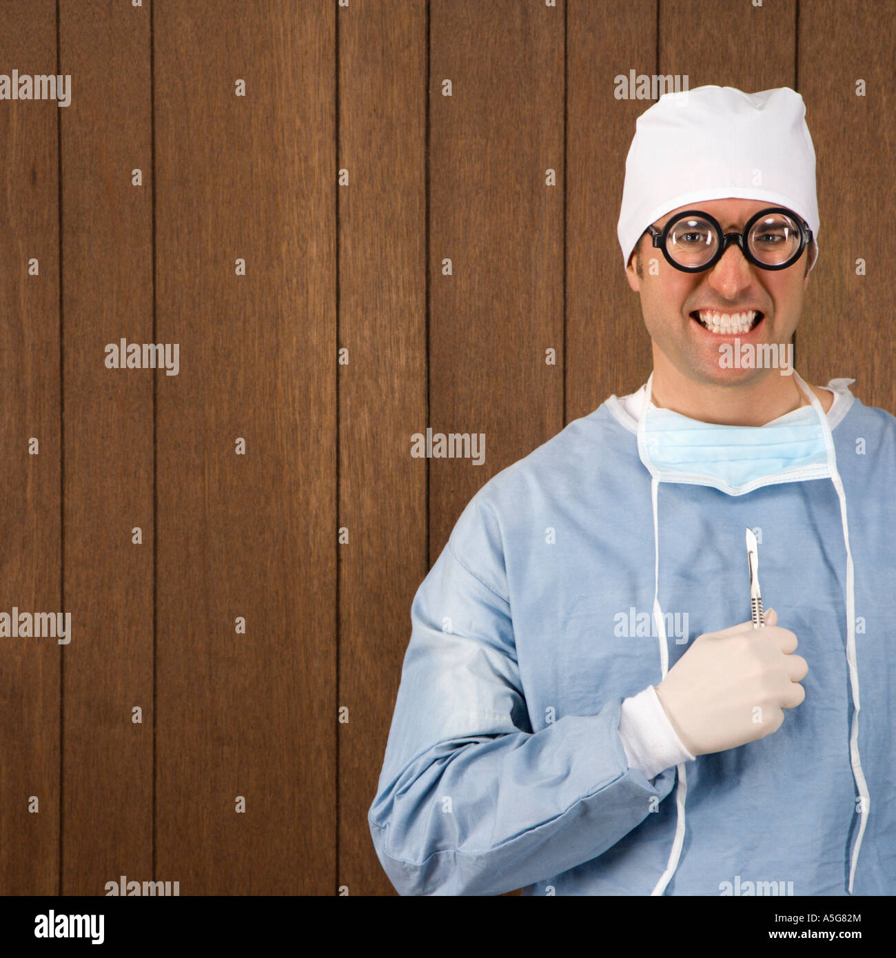 Mid adult Caucasian male surgeon wearing thick glasses and holding ...