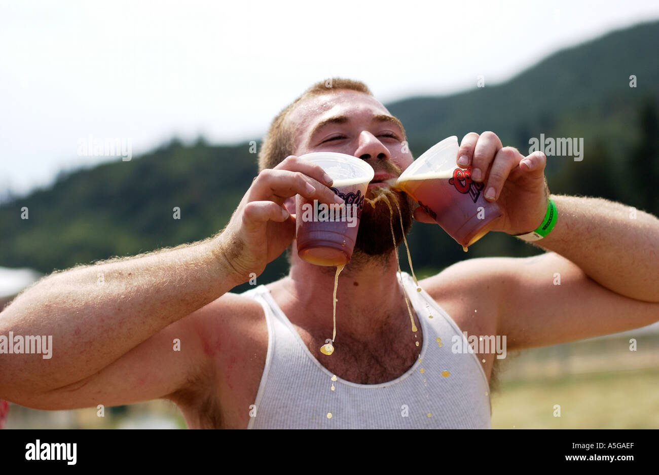 Guy drinking two beers at an outdoor concert Stock Photo
