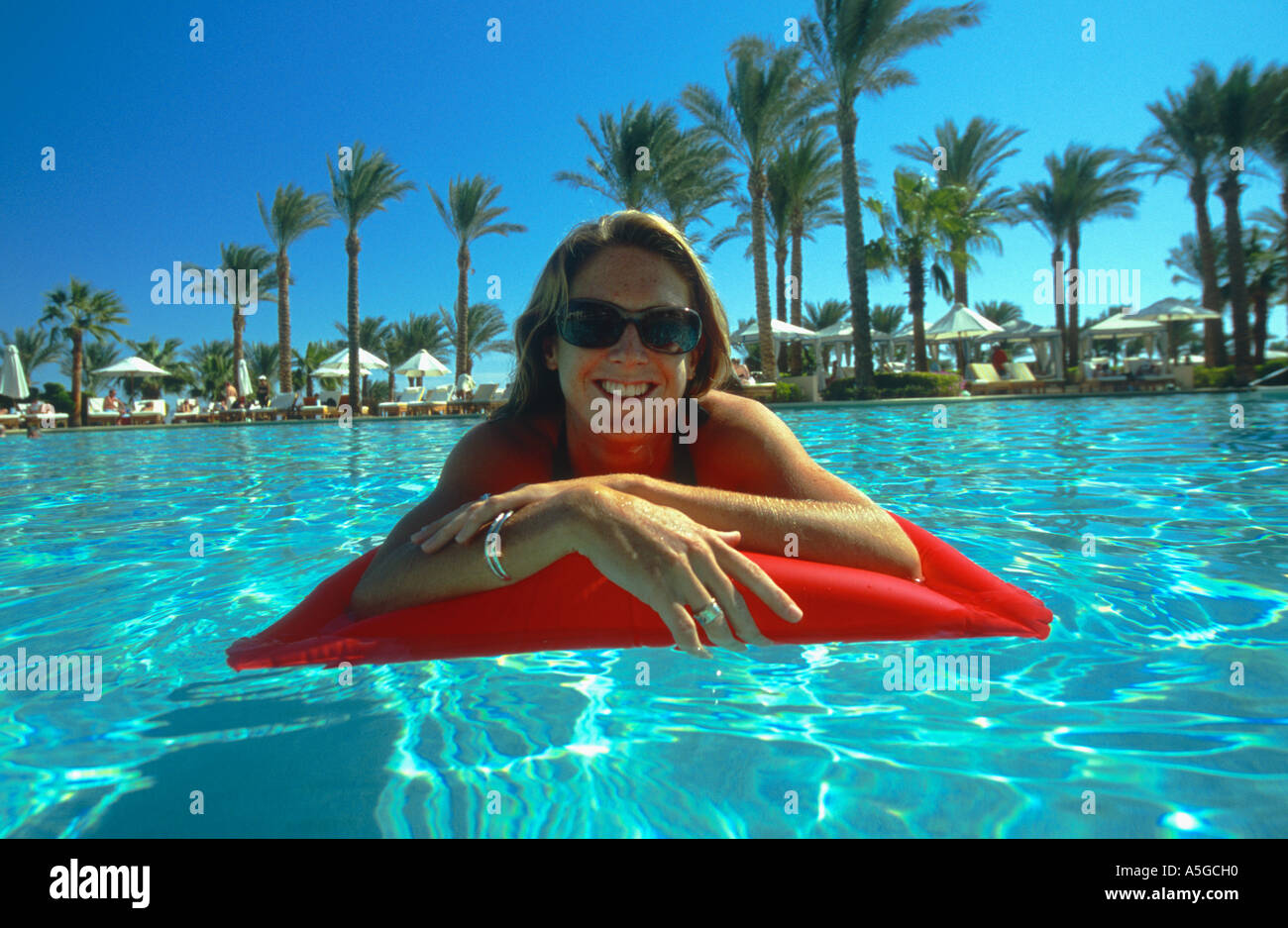 Girl floating on lilo reading book swimming pool Sharm el Sheikh Sinai