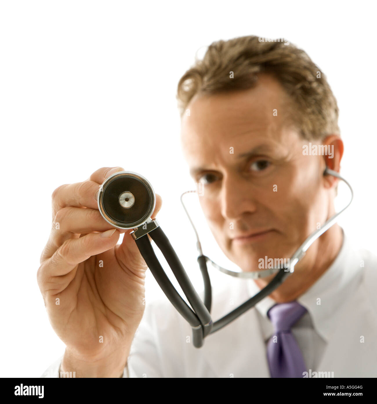 Portrait of a mid adult Caucasian male doctor holding out stethoscope ...