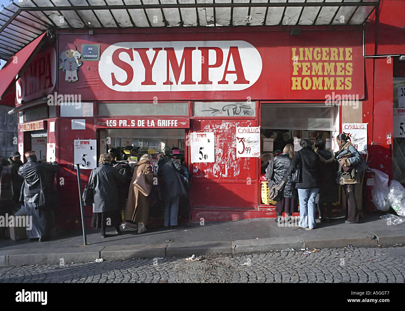 Shoppers crowd the sidewalks of Belleville Paris during the winter sales Stock Photo