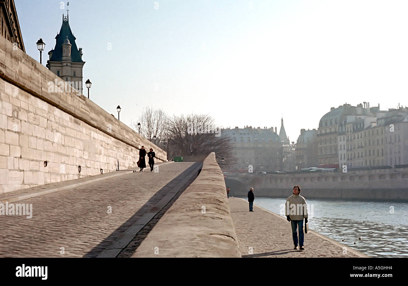 People taking a late afternoon stroll on the banks of the Seine river in Paris Stock Photo
