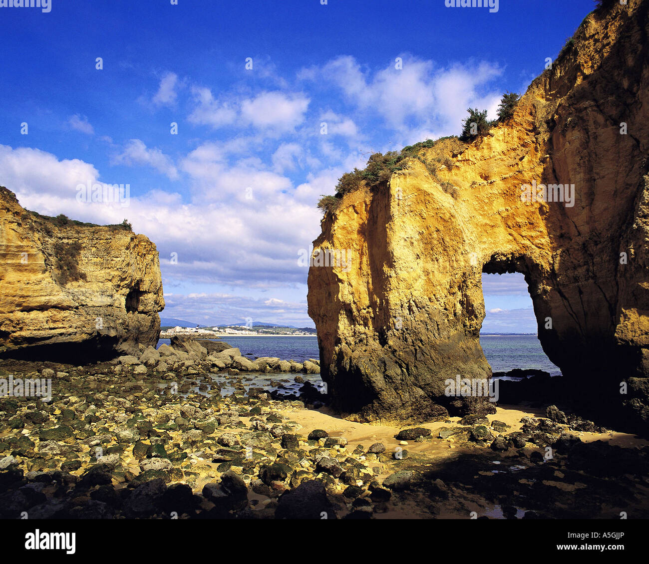 Rock formations including a natural arch along the shore at Lagos, Portugal, Algarve Stock Photo