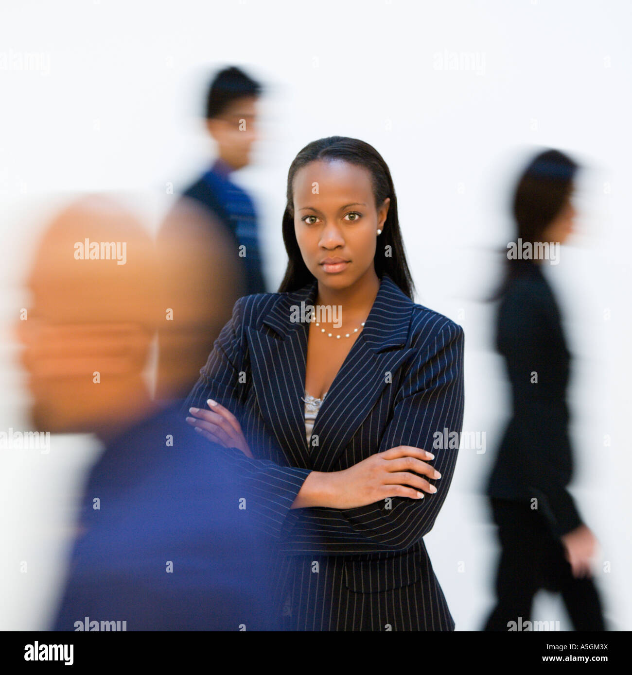 African American businesswoman standing with arms crossed while others ...