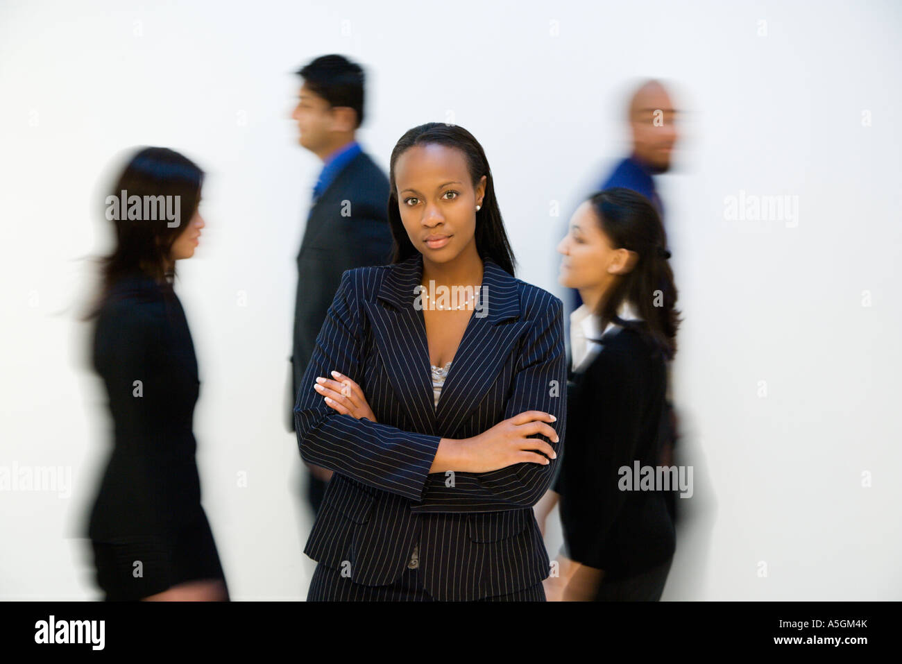African American businesswoman standing with arms crossed while others ...