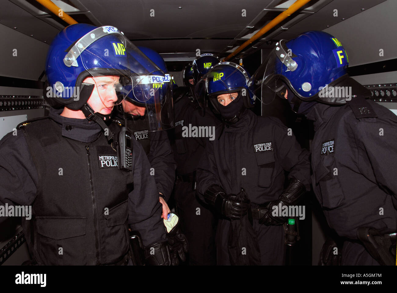 Police officers in riot gear in van en route to raid a crack house in Fulham,  west London, UK. Stock Photo