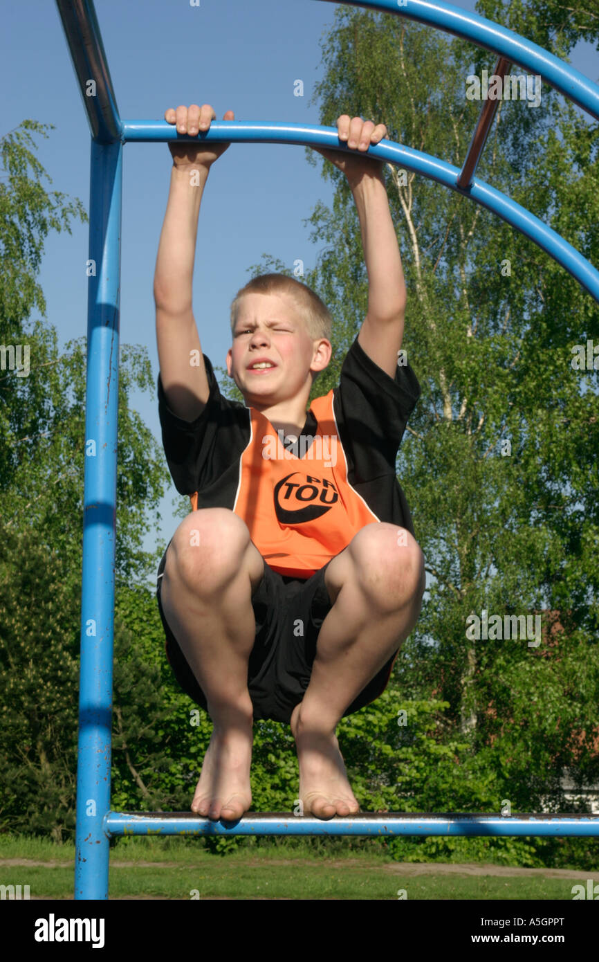 a young boy climbing monkey bars on a playground Stock Photo Alamy