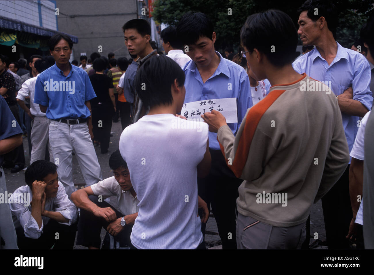 China 2000s. Chinese economy men unemployed workers, advertise their skills at job market Yiwu Zhejiang Province 2001 HOMER SYKES Stock Photo