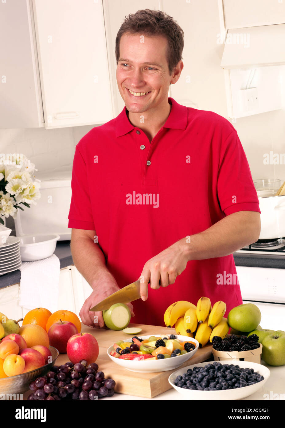 MAN IN KITCHEN CUTTING FRUIT Stock Photo Alamy