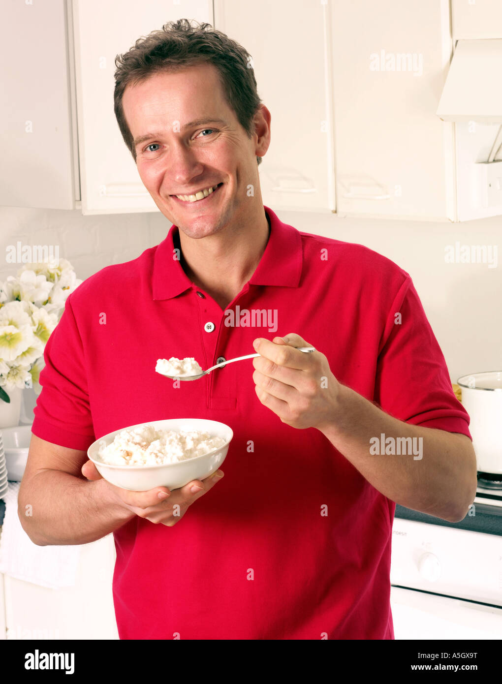 MAN IN KITCHEN EATING COTTAGE CHEESE Stock Photo Alamy