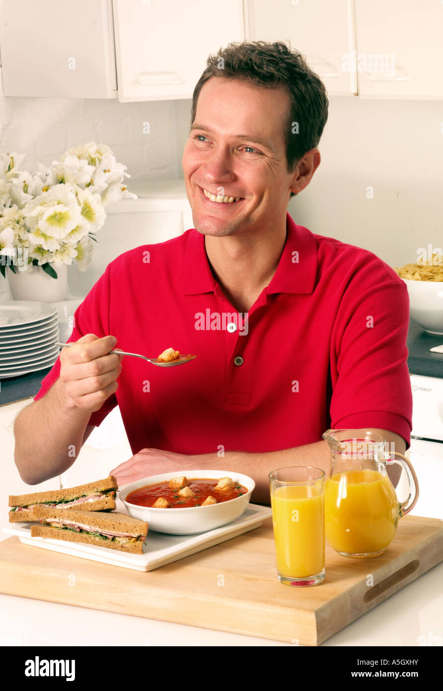MAN IN KITCHEN EATING SOUP FOR LUNCH Stock Photo Alamy