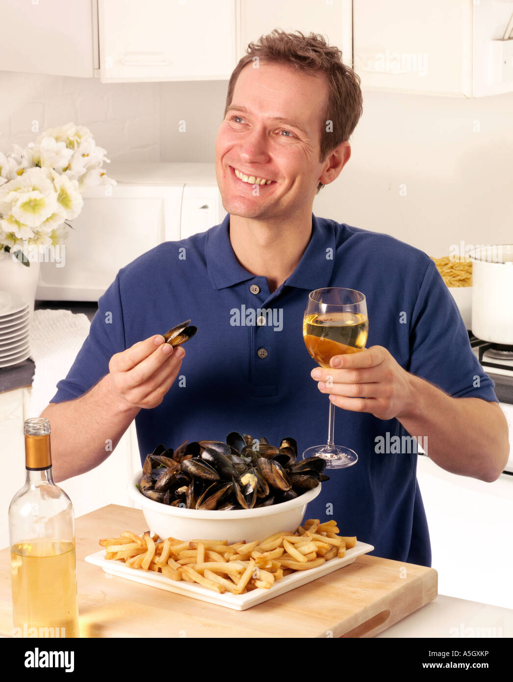 MAN EATING MUSSELS AND FRENCH FRIES OR MOULES FRITES Stock Photo Alamy