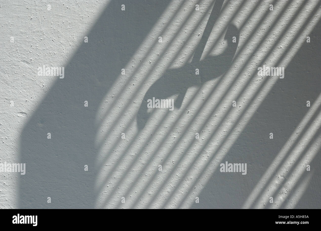 light and shade of a window shutter against a wall Stock Photo
