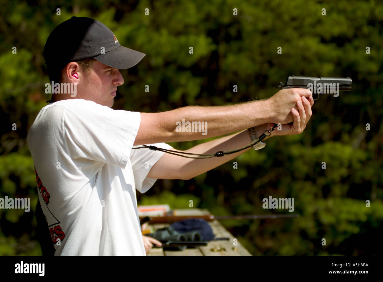 Teenage boy shooting hand gun at target at shooting range in Ocala