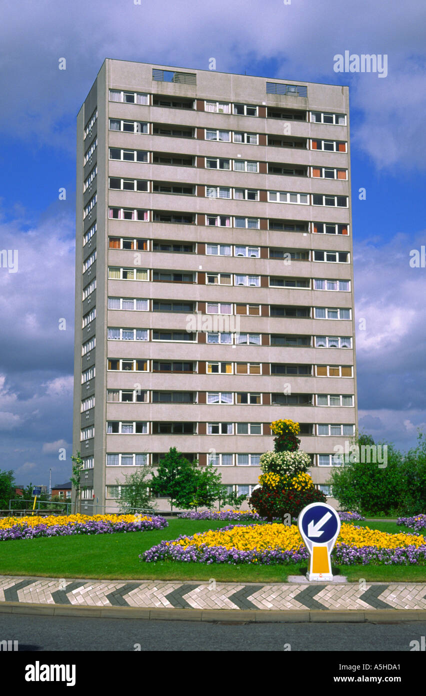 High rise tower block of flats and flowers on a traffic island ...