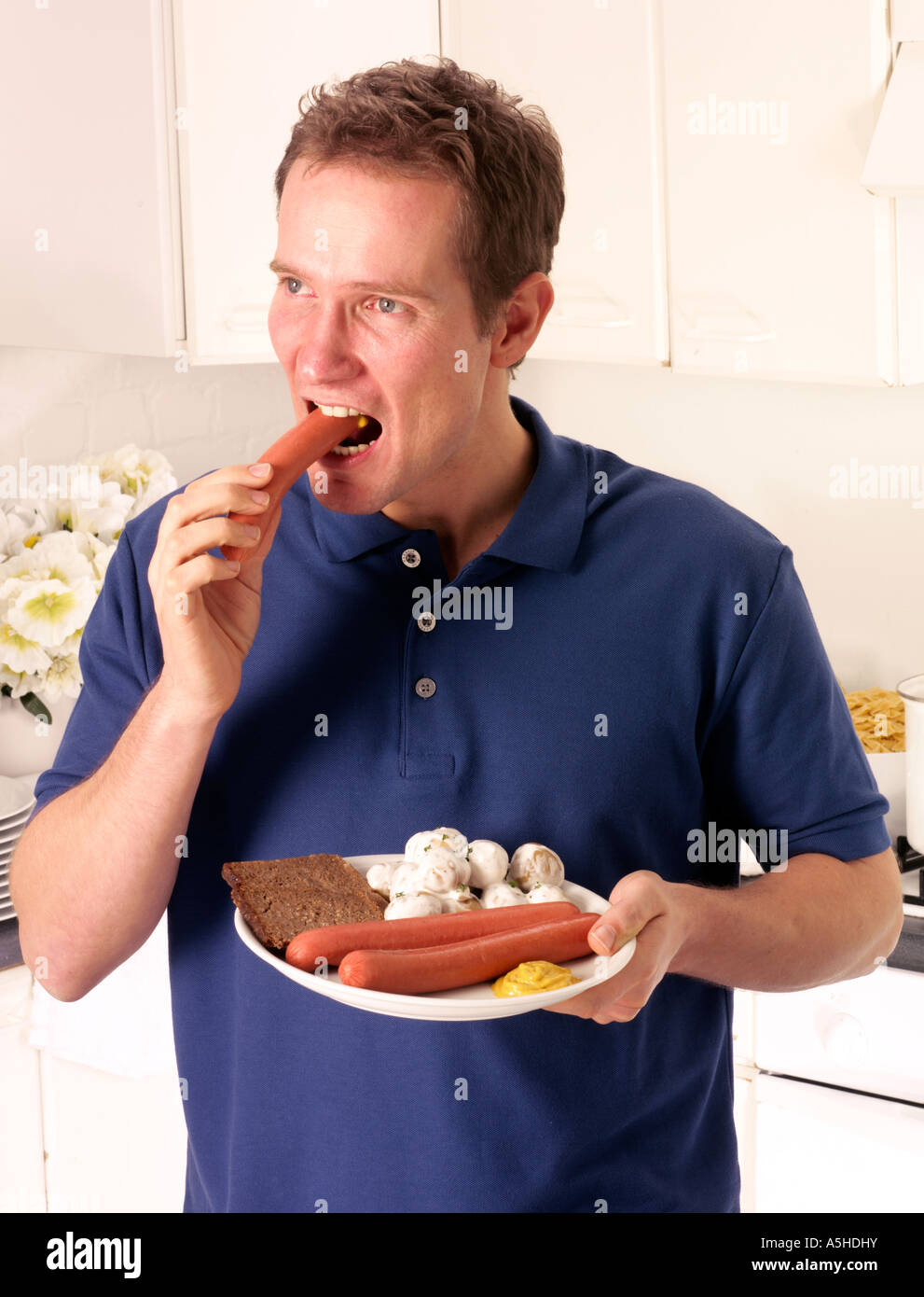 MAN EATING FRANKFURTERS AND POTATO SALAD Stock Photo - Alamy