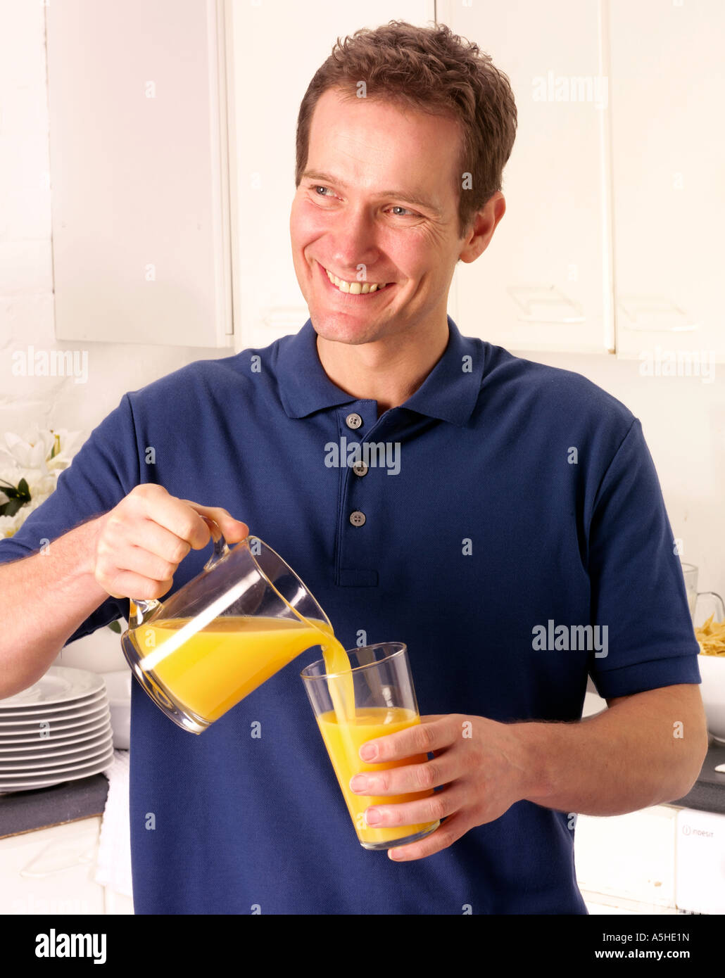 MAN IN KITCHEN POURING ORANGE JUICE Stock Photo Alamy