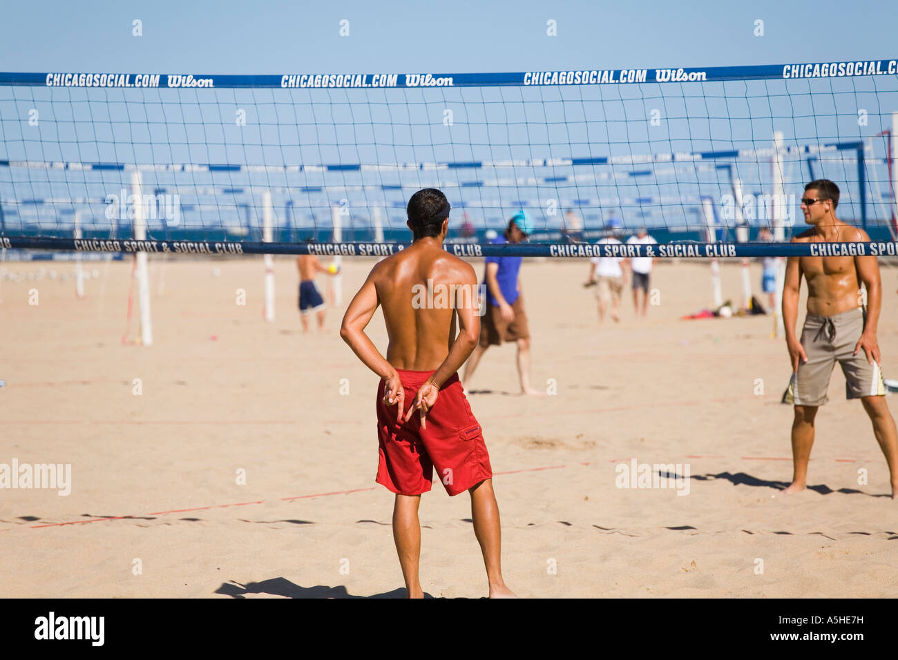 ILLINOIS Chicago Two on two teams of men play beach volleyball at North  Avenue Beach signal team mate behind back Stock Photo - Alamy