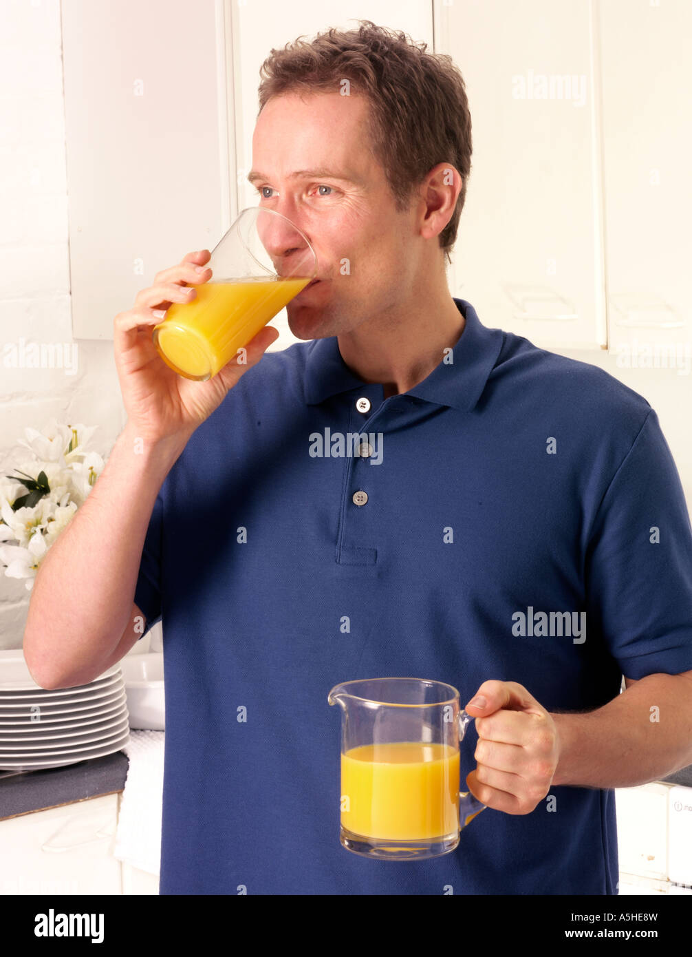 MAN IN KITCHEN DRINKING ORANGE JUICE Stock Photo Alamy