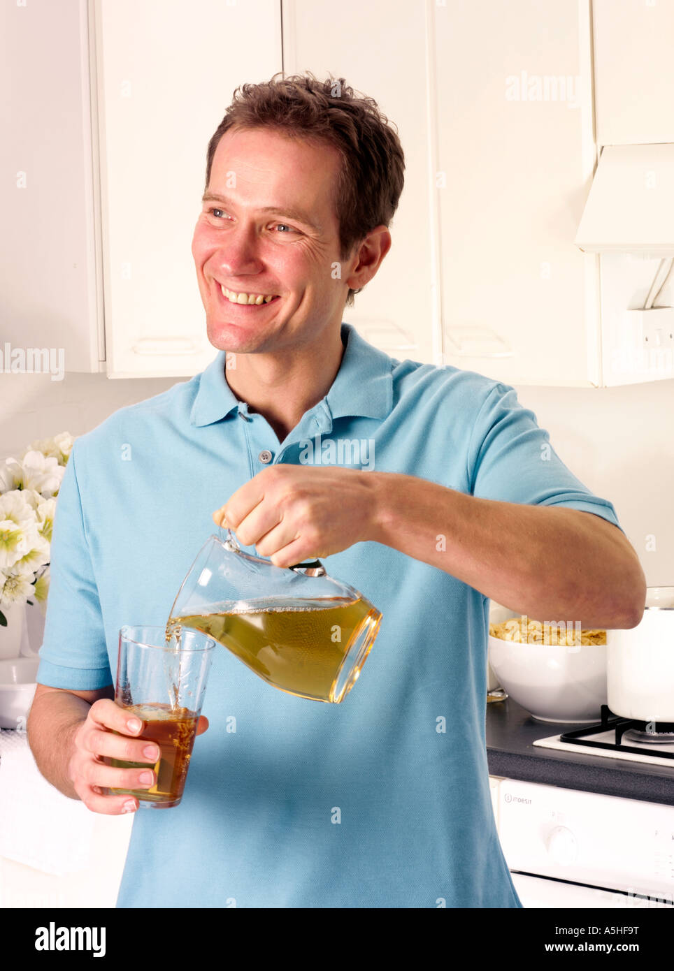 MAN IN KITCHEN POURING APPLE JUICE Stock Photo Alamy