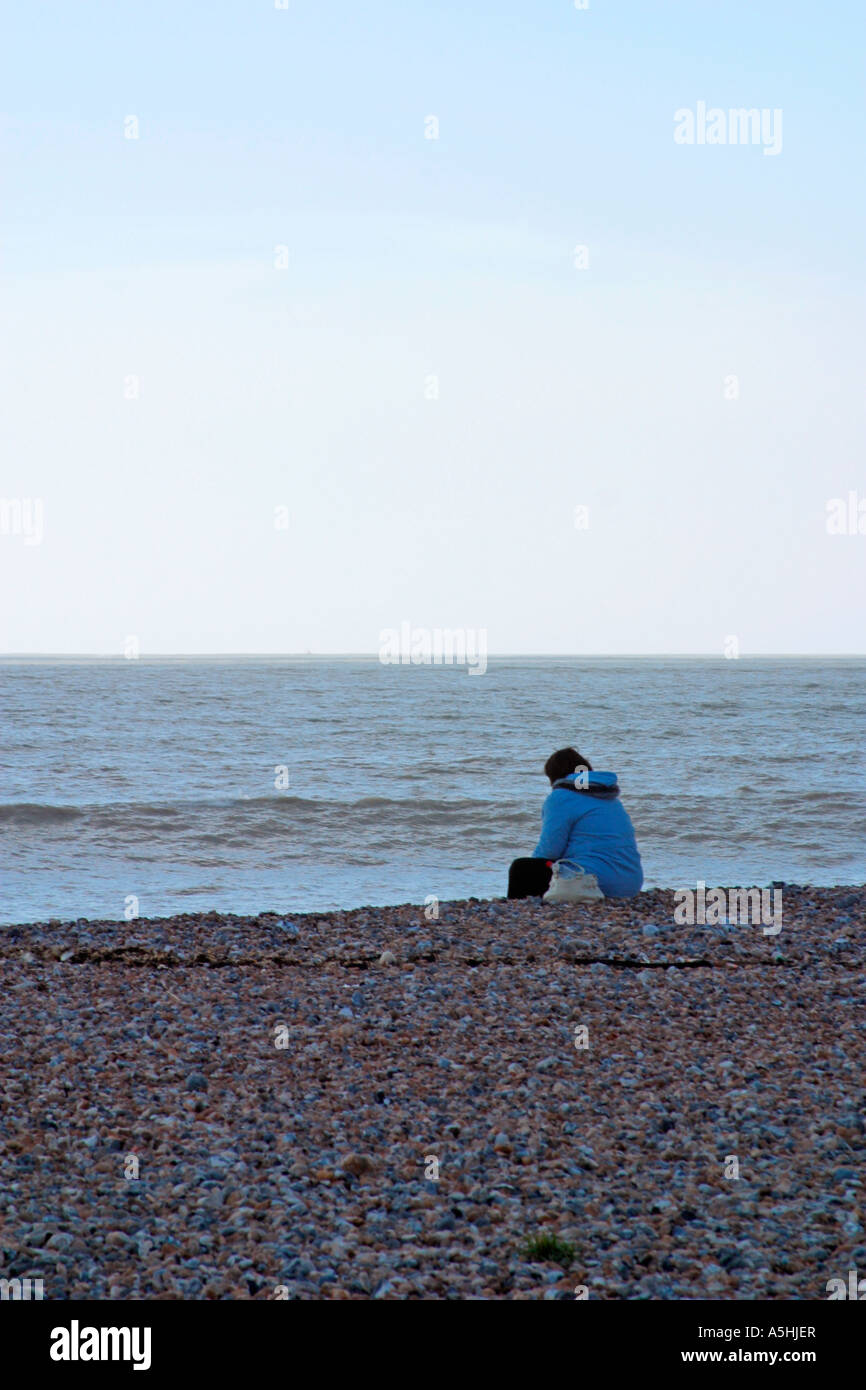 Female sitting alone on beach in Worthing, UK Stock Photo - Alamy