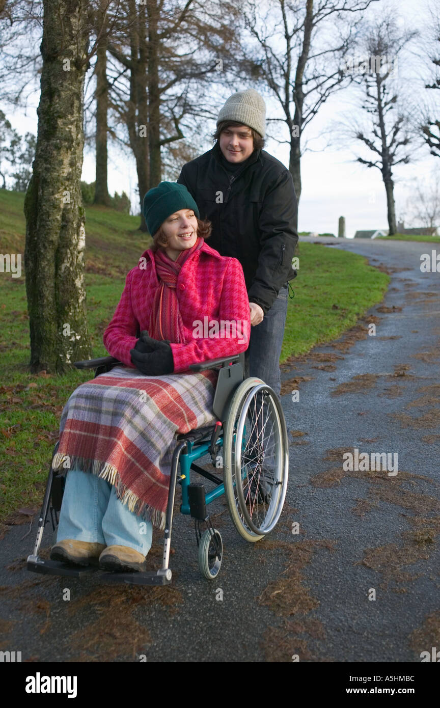 Disabled woman and partner in park Stock Photo