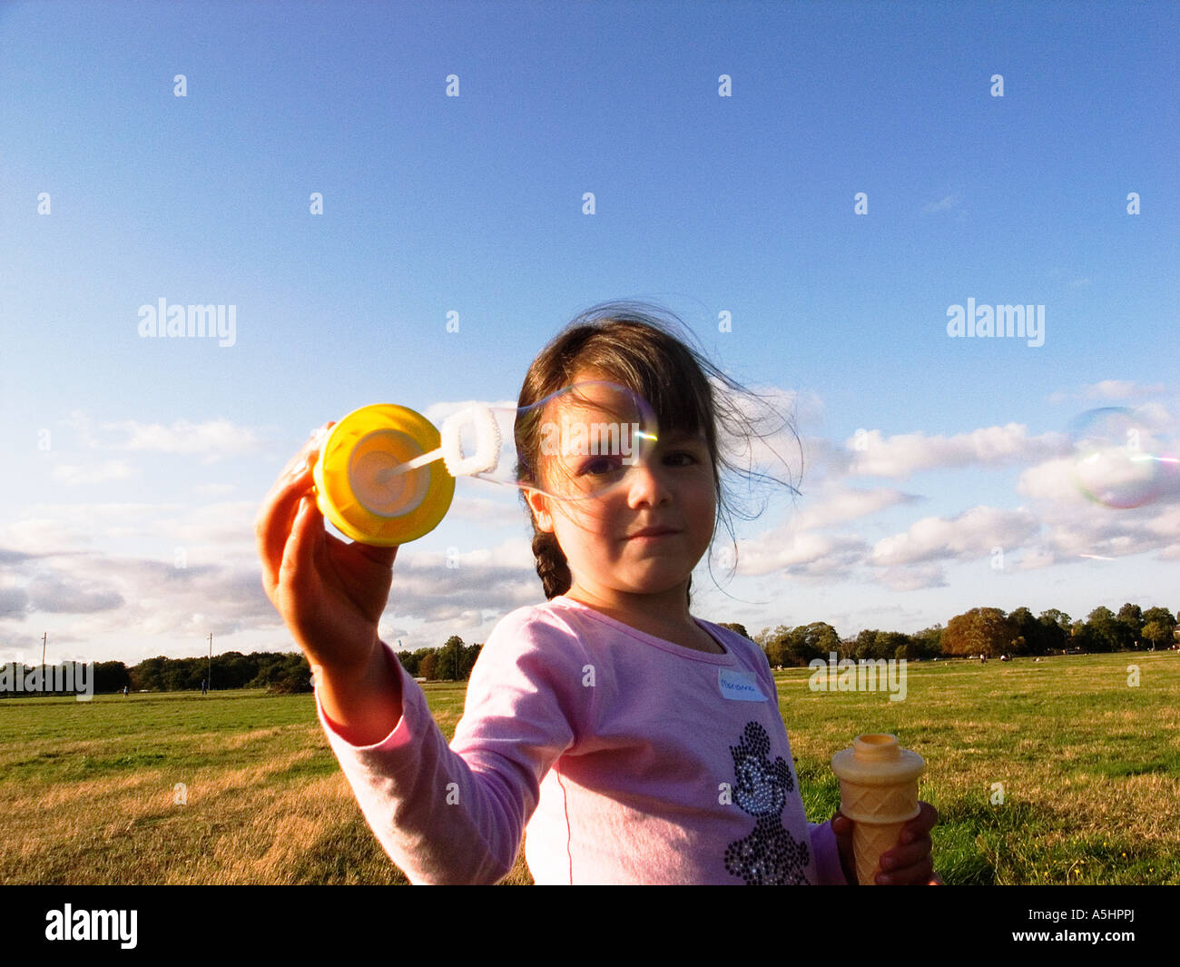 little girl playing with soap bubbles in the park Stock Photo - Alamy