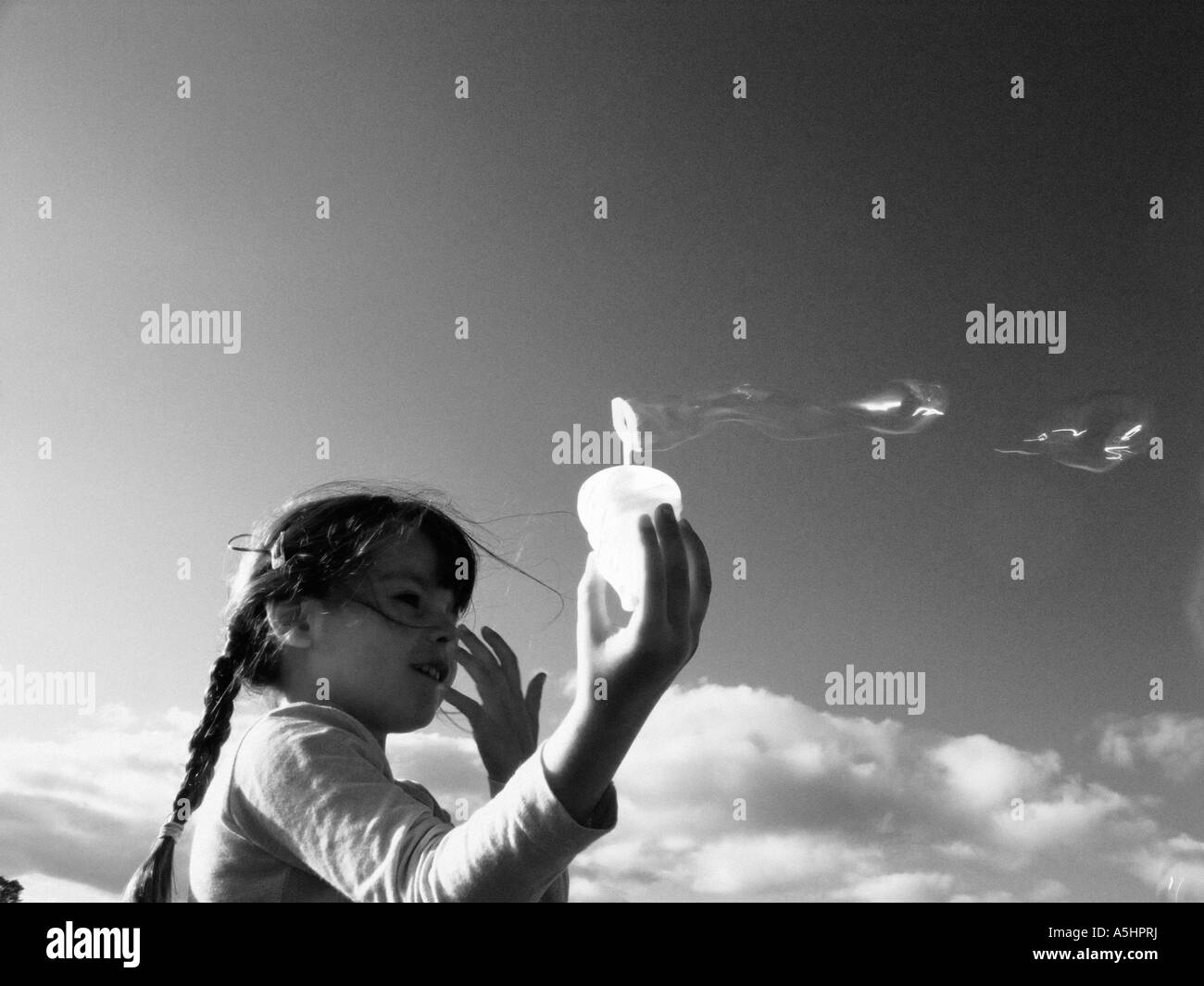 little girl playing with soap bubbles in the park Stock Photo - Alamy