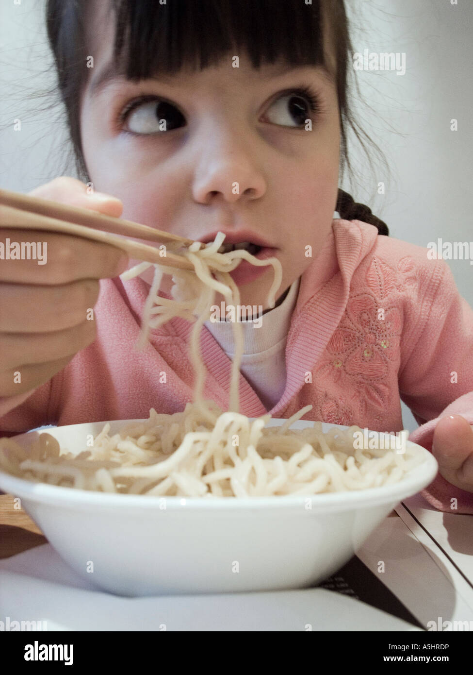little girl eating noodles in oriental restaurant Stock Photo Alamy