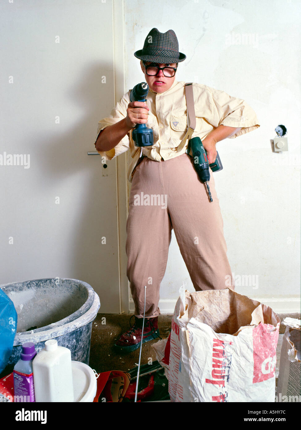 MR PR silly handyman do it yourselfer renovating a flat holding drilling machine like a weapon Stock Photo