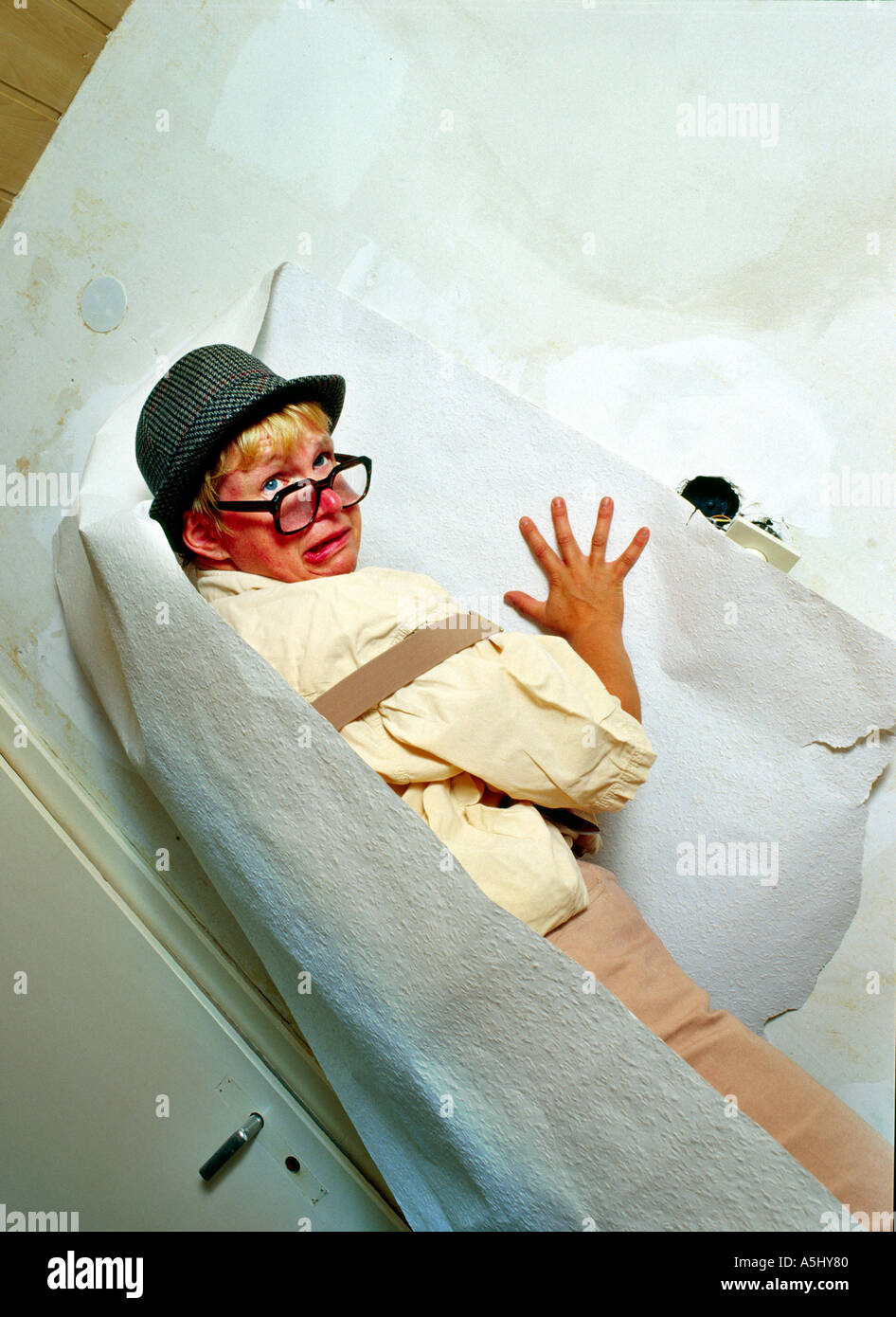 MR PR silly handyman do it yourselfer renovating a flat papering the walls Stock Photo