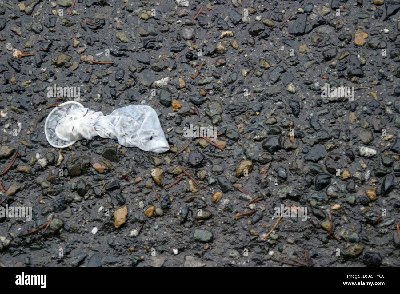 discarded used condom on roadside Stock Photo