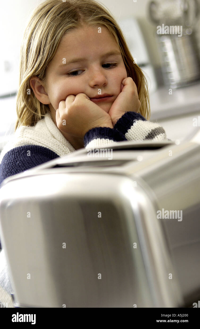 Young girl waiting on toaster Stock Photo Alamy