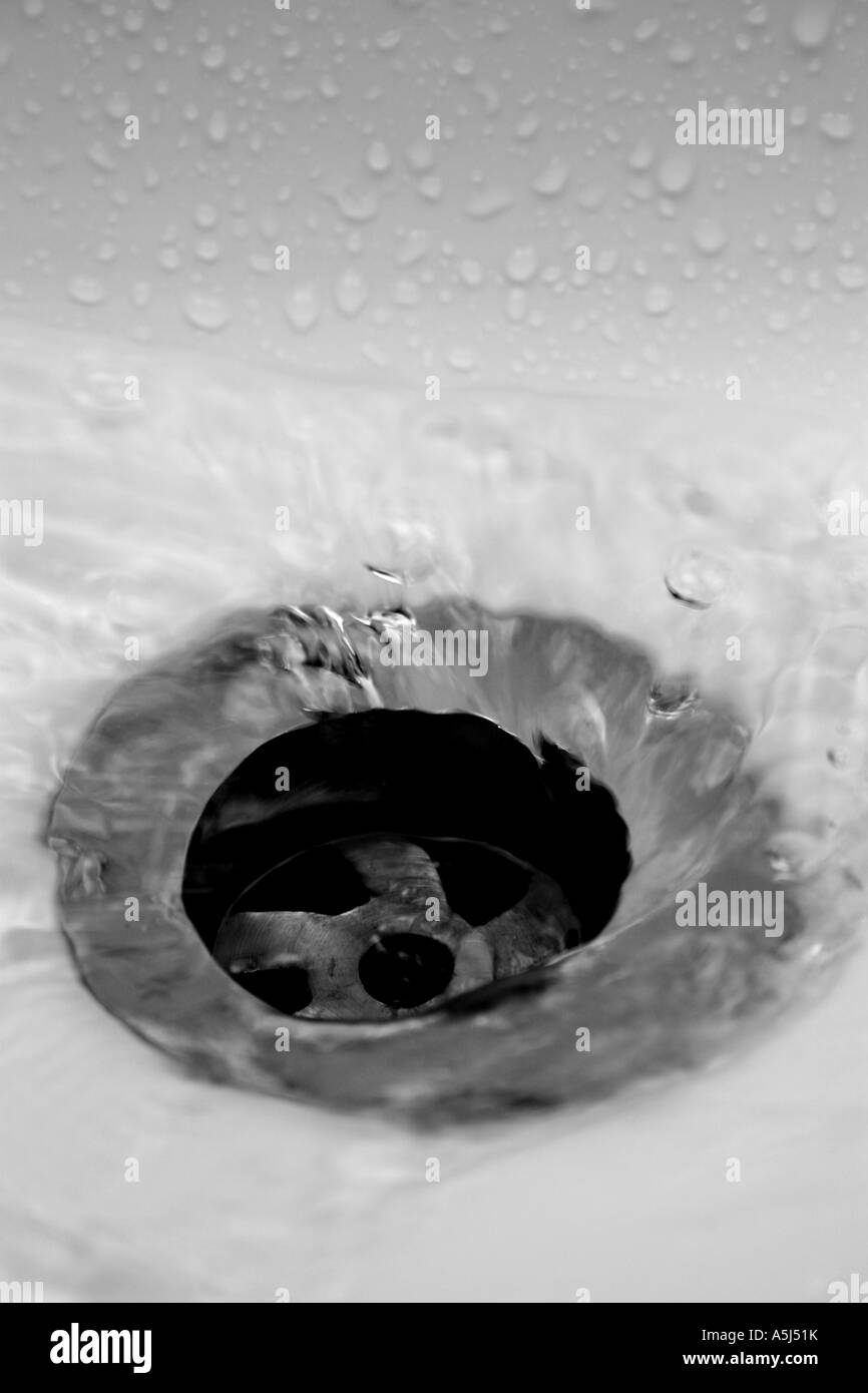 water spiralling down the plughole of a bathroom sink Stock Photo
