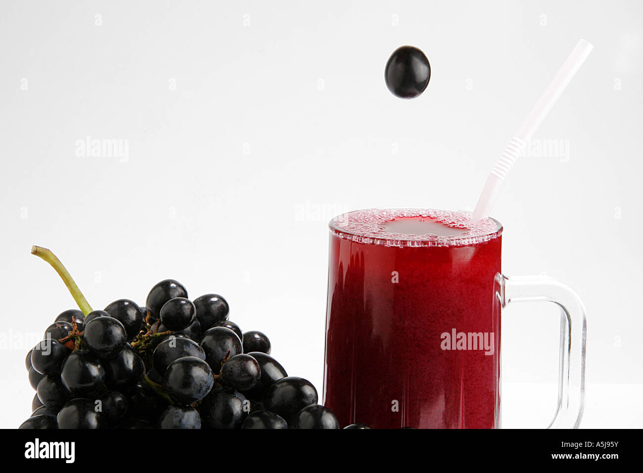 Fruit black grapes glass juice white backround Stock Photo