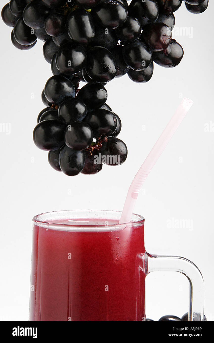 Fruit black grapes glass juice white background Stock Photo