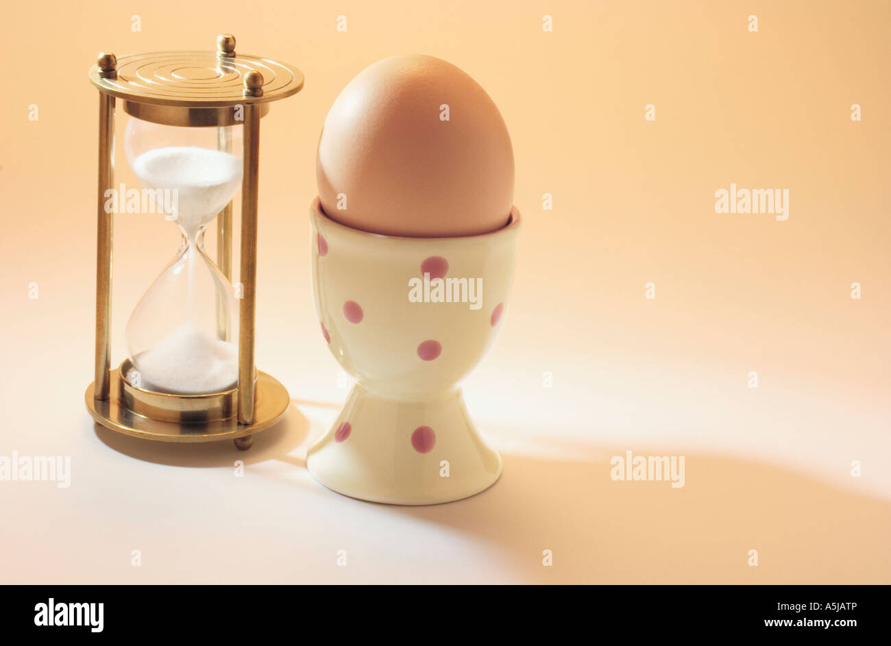 Hourglass with Egg on Eggcup Stock Photo