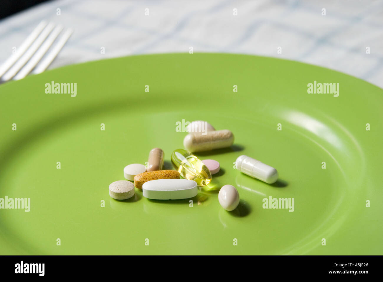 vitamins supplements lying on plate table setting nutrition good health Stock Photo