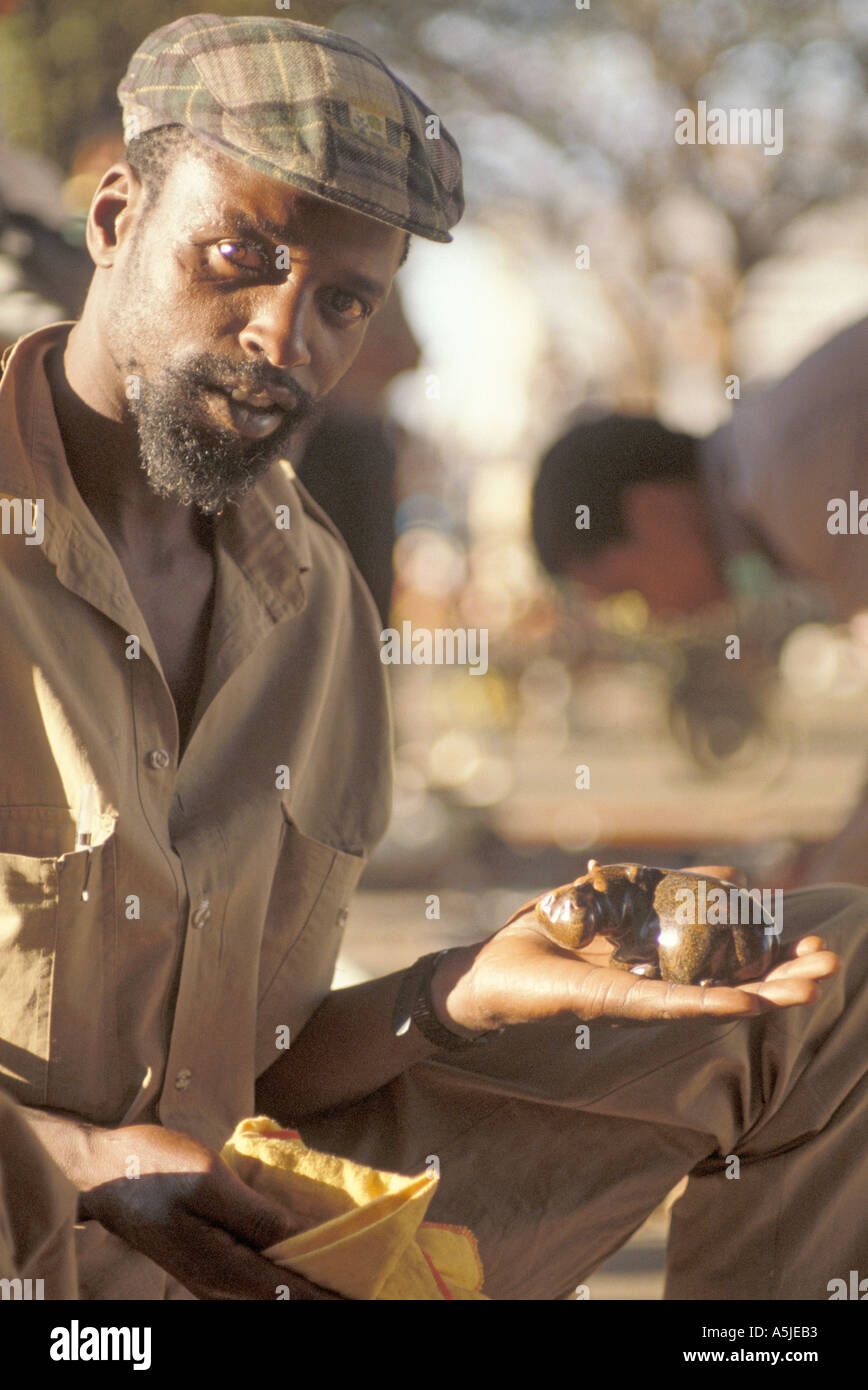 An African craftsperson a stone carver is selling his wares at a street