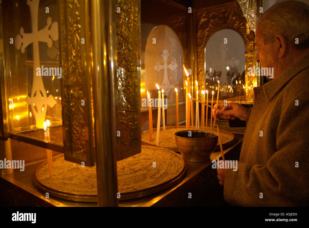 Man lighting a candle in a Greek Orthodox church Stock Photo Alamy