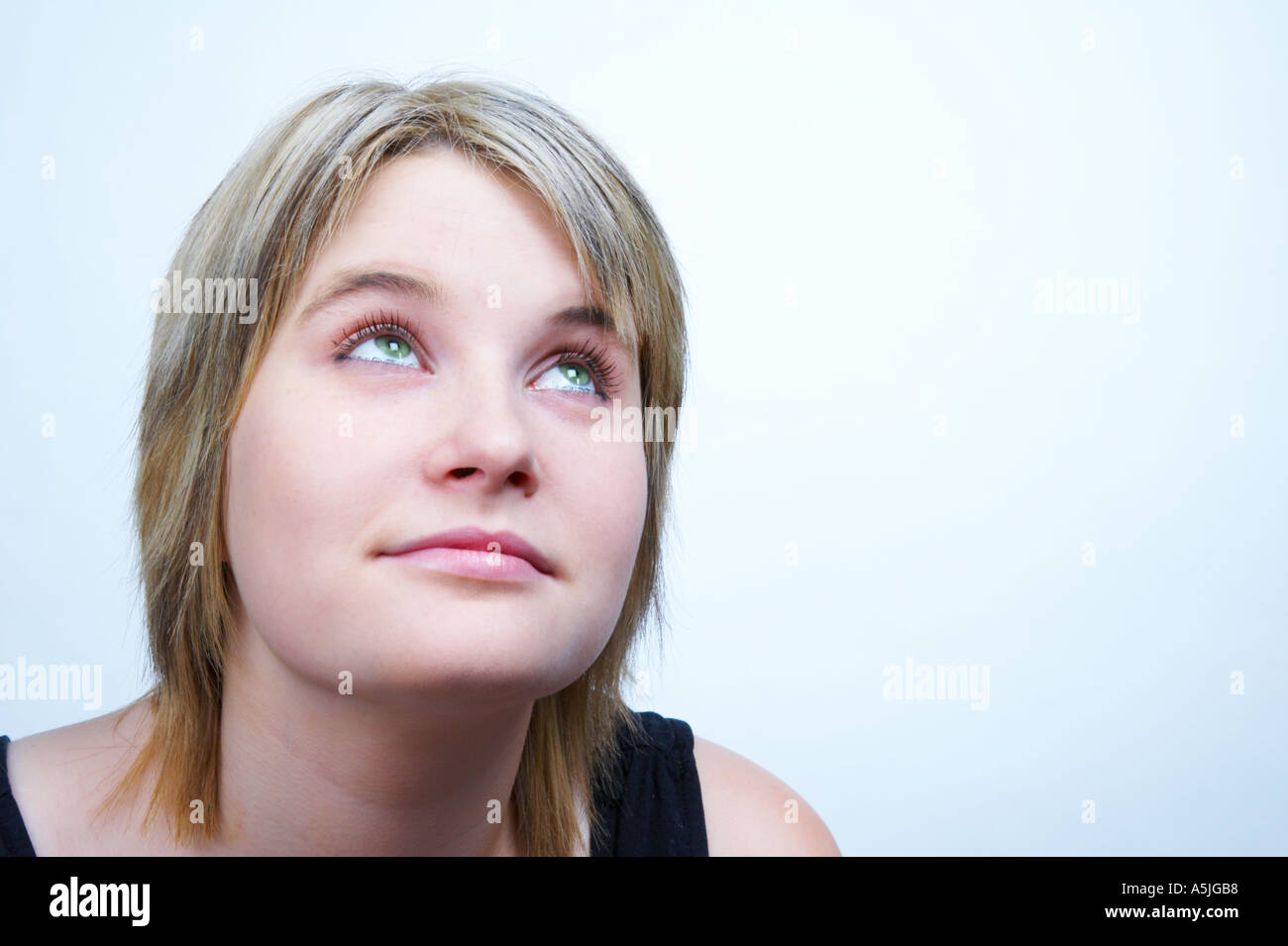 Teenage Girl looking upward Bleeched Blue Horizontal Stock Photo - Alamy