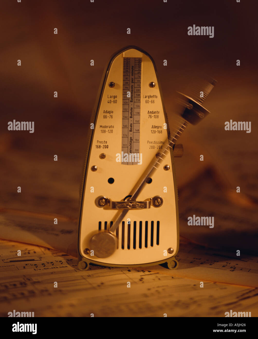 metronome on music sheets background Stock Photo Alamy