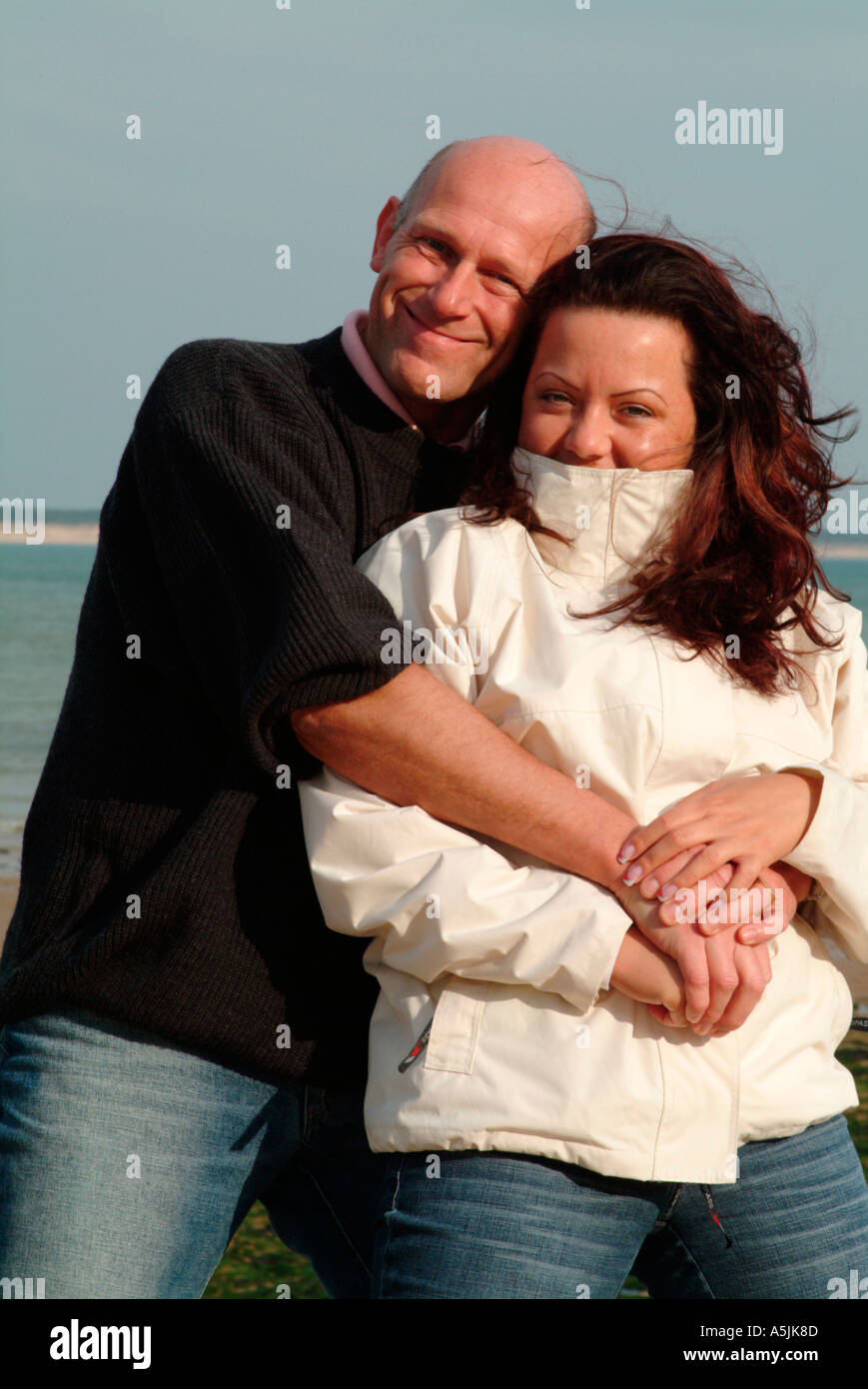 MR lovers walking at seacoast in tender embracement Stock Photo