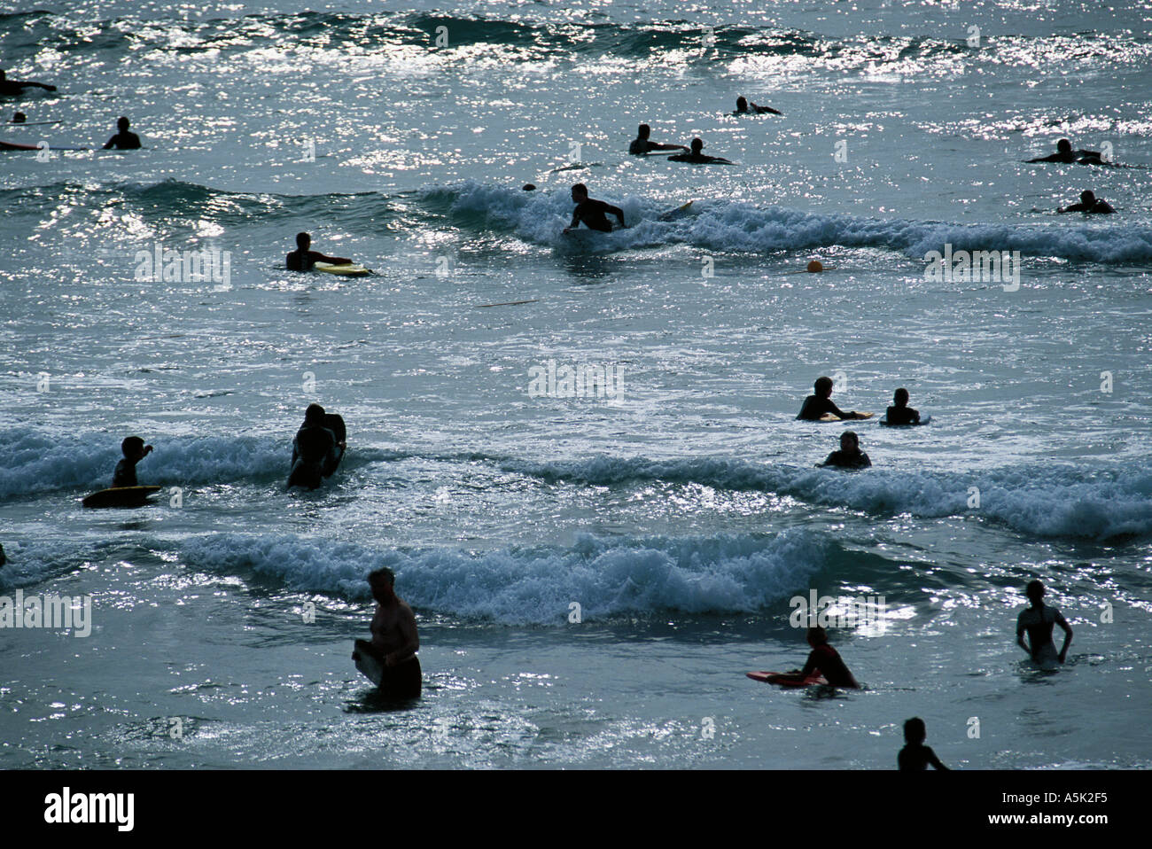 Playing in the surf Polzeath near Padstow Cornwall Great Britain Stock